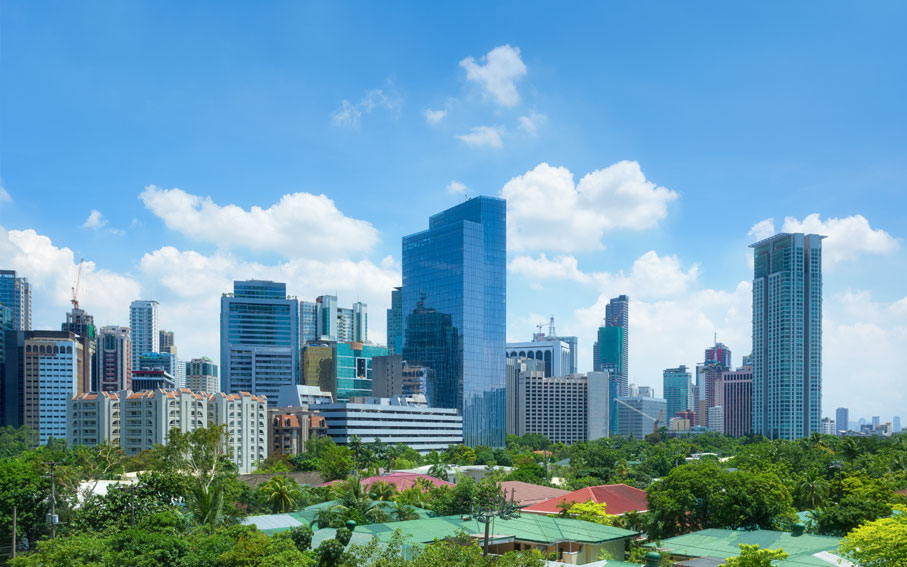 High-rise towers rising behind green parkland in the Philippines